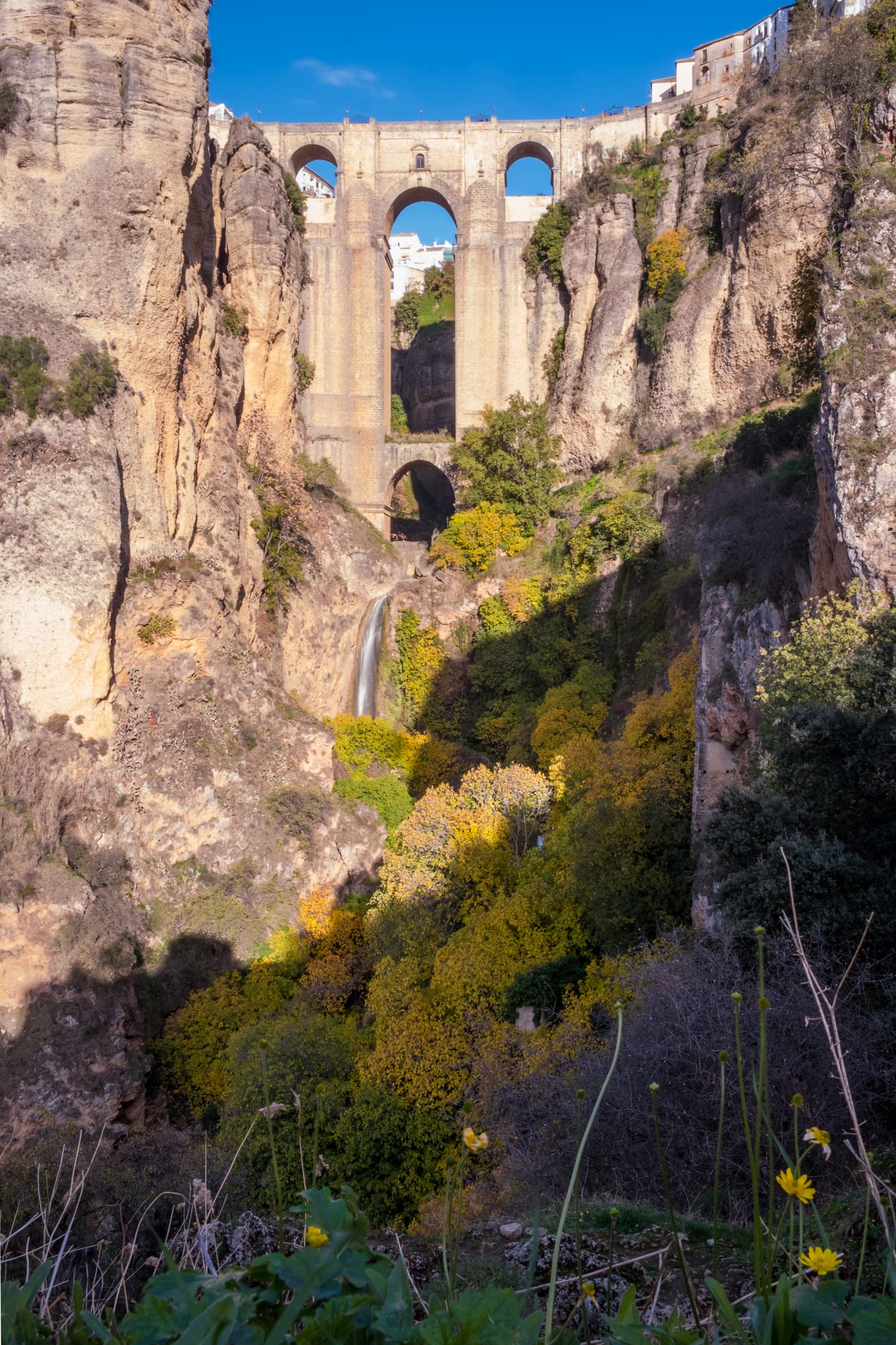 Puente Nuevo with autumnal trees and waterfall