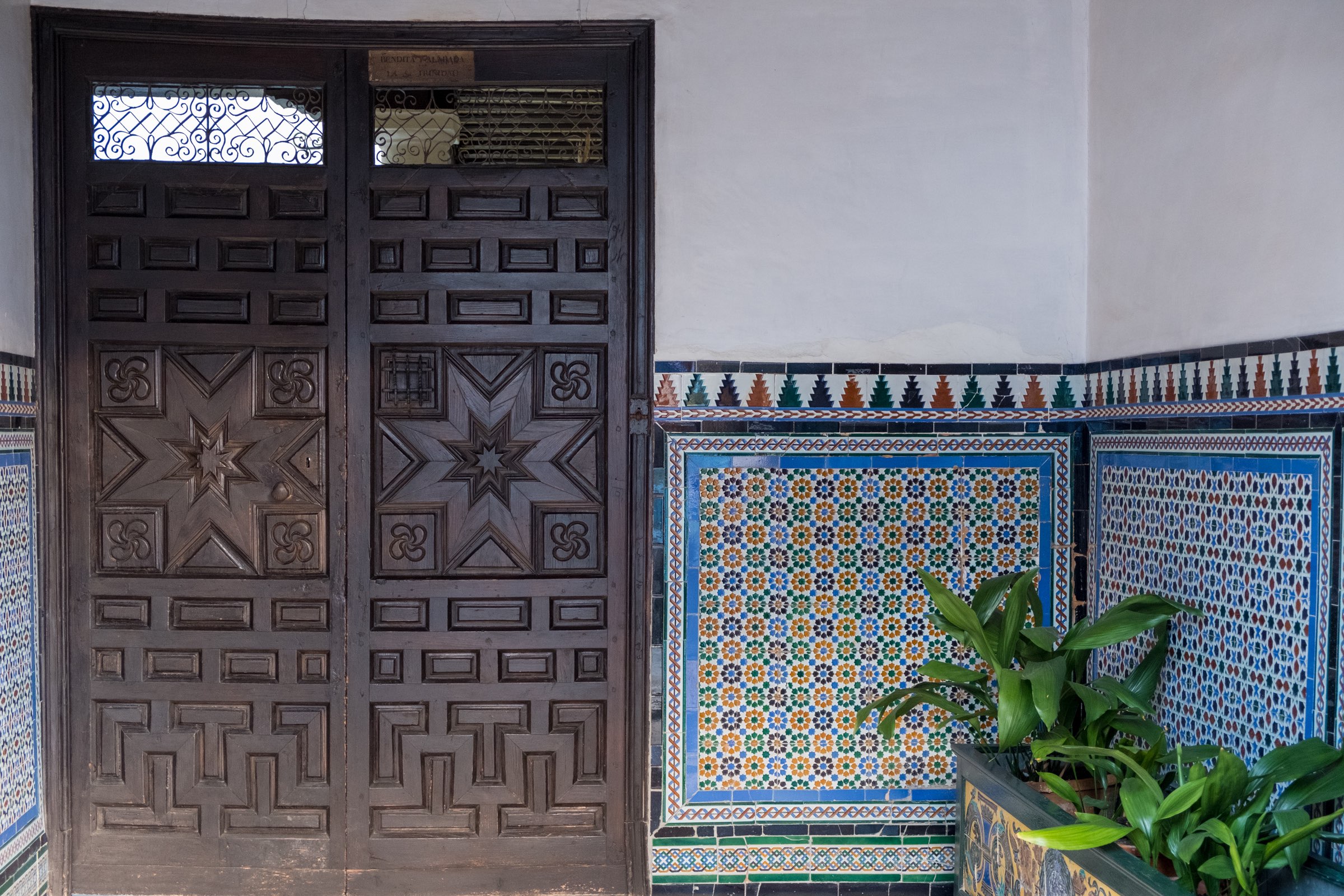 Pretty door and tiles with geometric patterns in an porch in Ronda