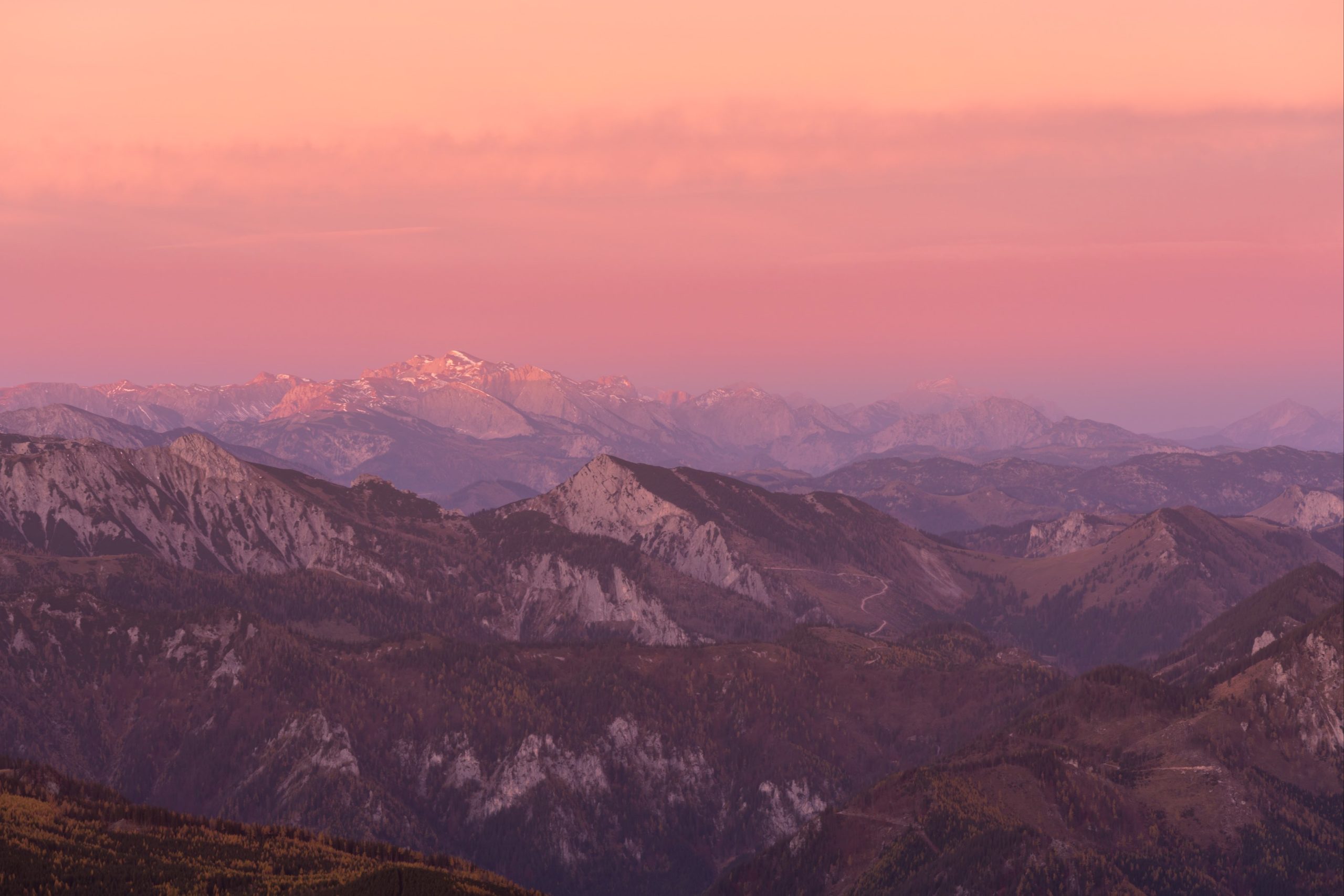 Vibrant pinks and reds over the mountain peaks of Austria including the Rax plateau from Schneeberg