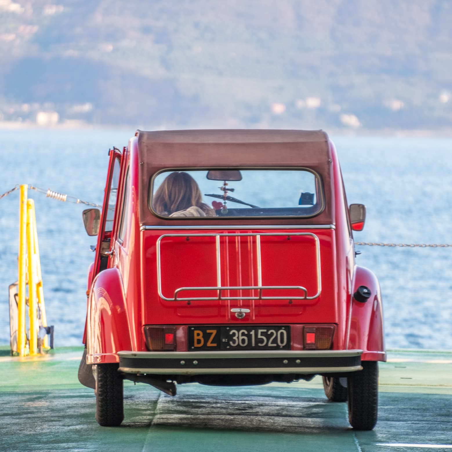 Classic vintage red car on a ferry on lake Garda, Italy