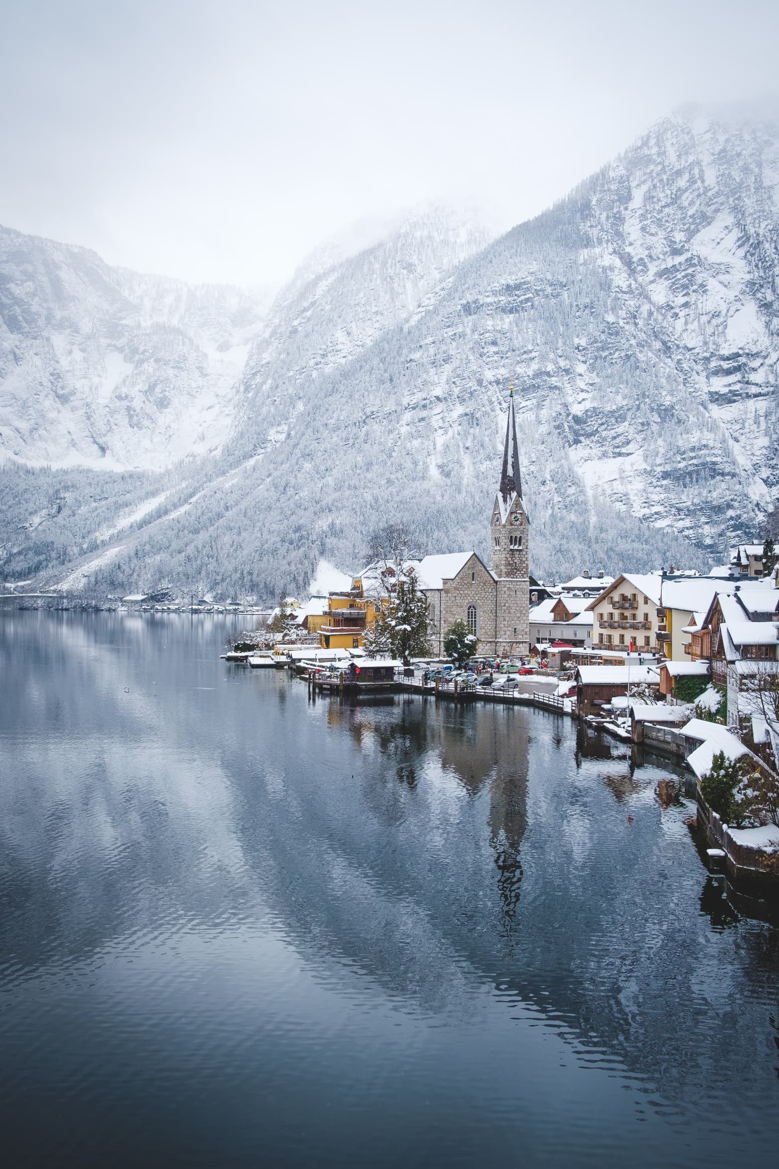 Hallstatt in the snow with focus on the church at the lake front