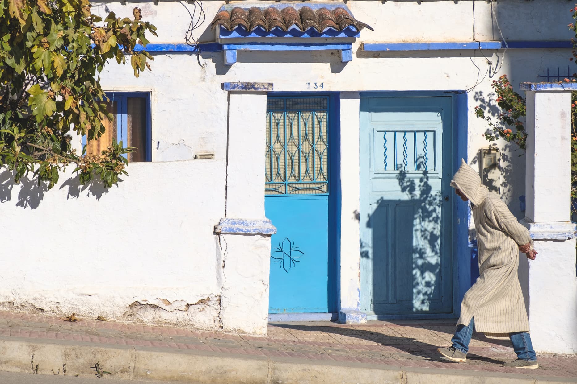 A berber man walking the outskirts of Chefchaouen in traditional robe looking very stoic in his pose, Morocco