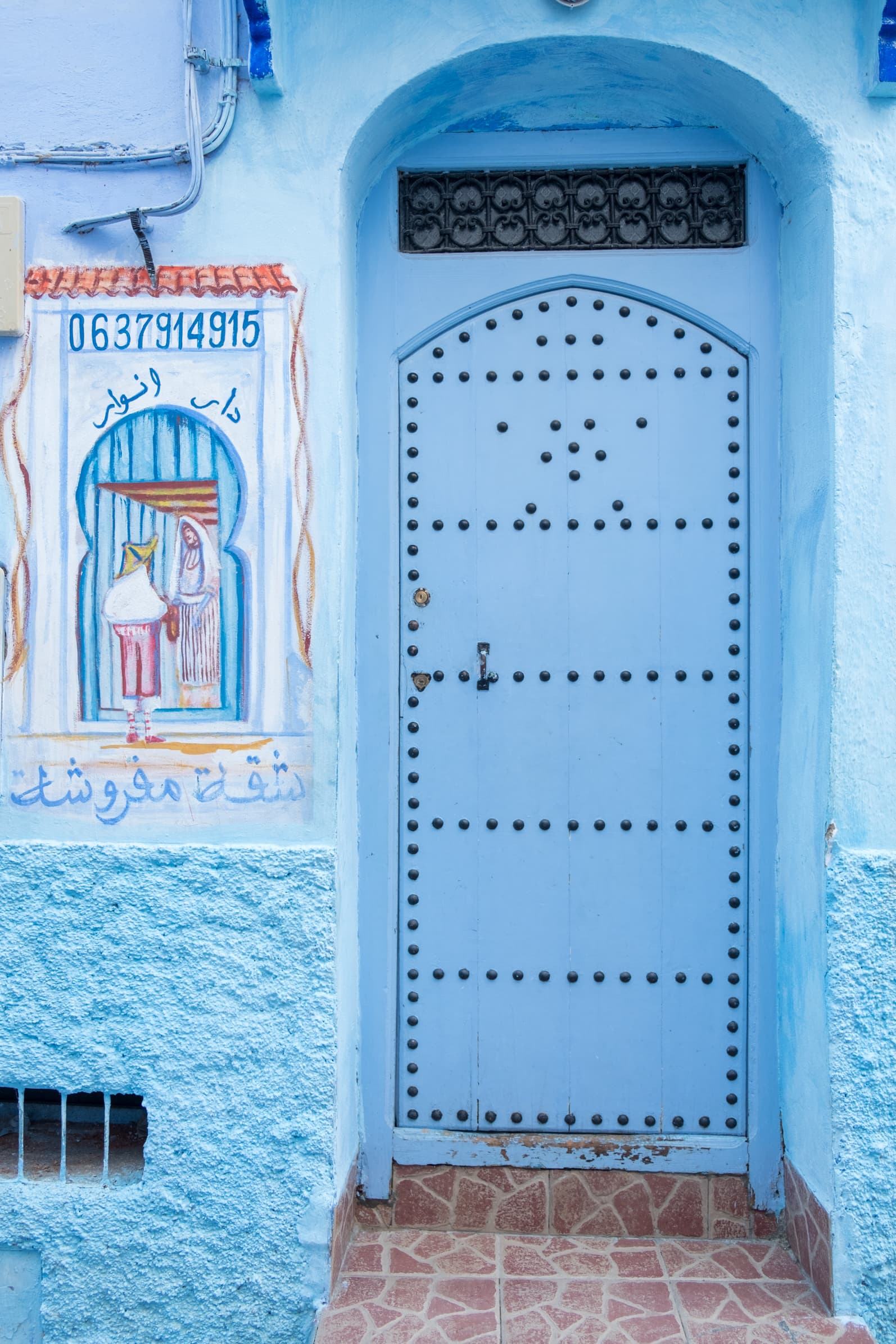 A blue doorway with painted artwork Chefchaouen, Morocco