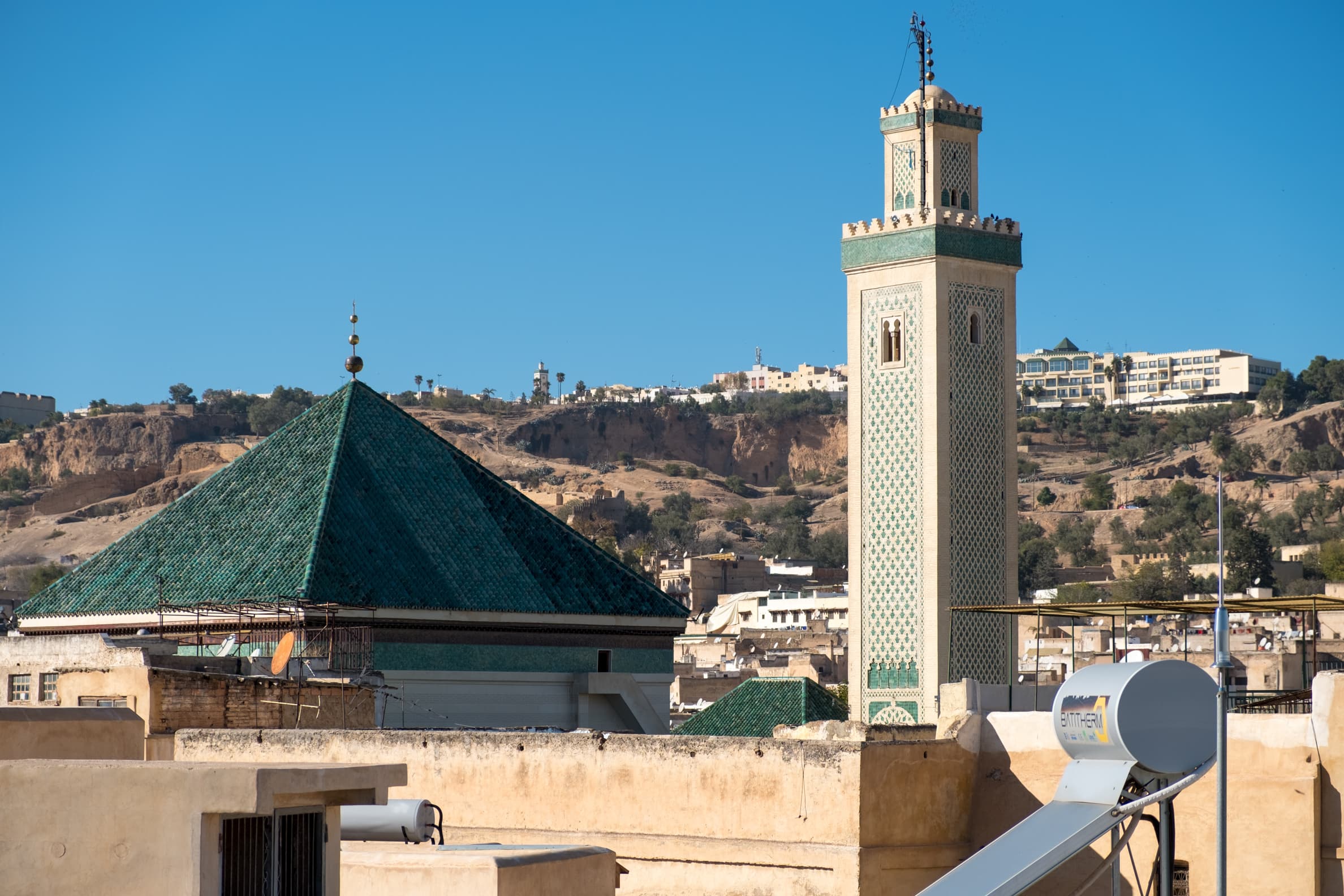 A green minaret and rooftop in Fez, Morocco