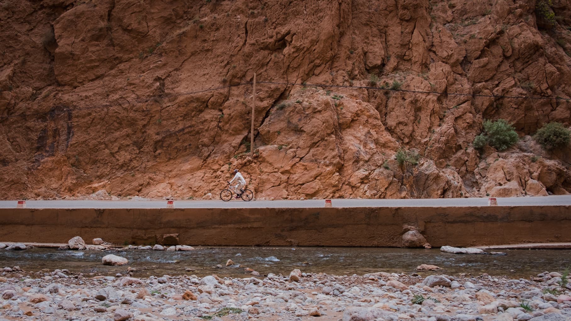 A man riding a bike through Todra gorge