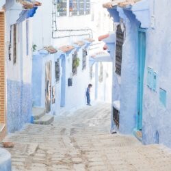 A small girl standing in the blue streets of Chefchaouen, Morocco