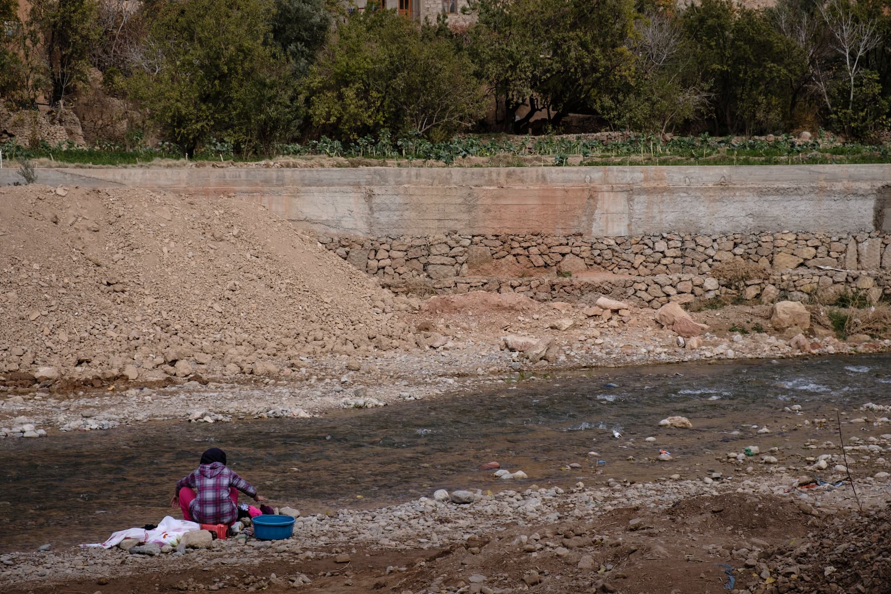 A woman washing clothes in the Todra river