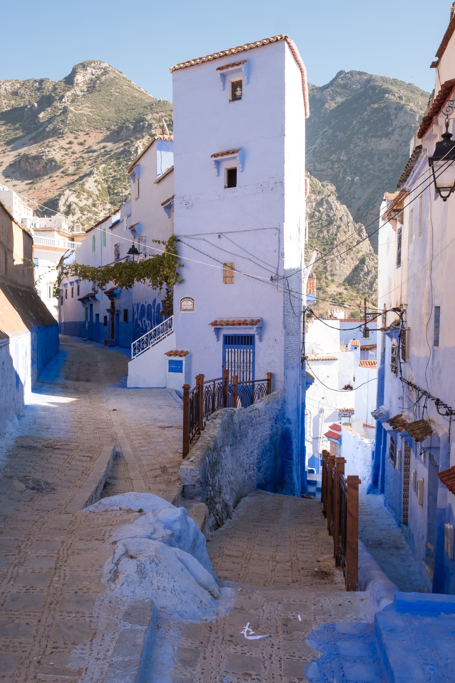 Side streets of Chefchaouen with the Riff mountains towering behind, Morocco