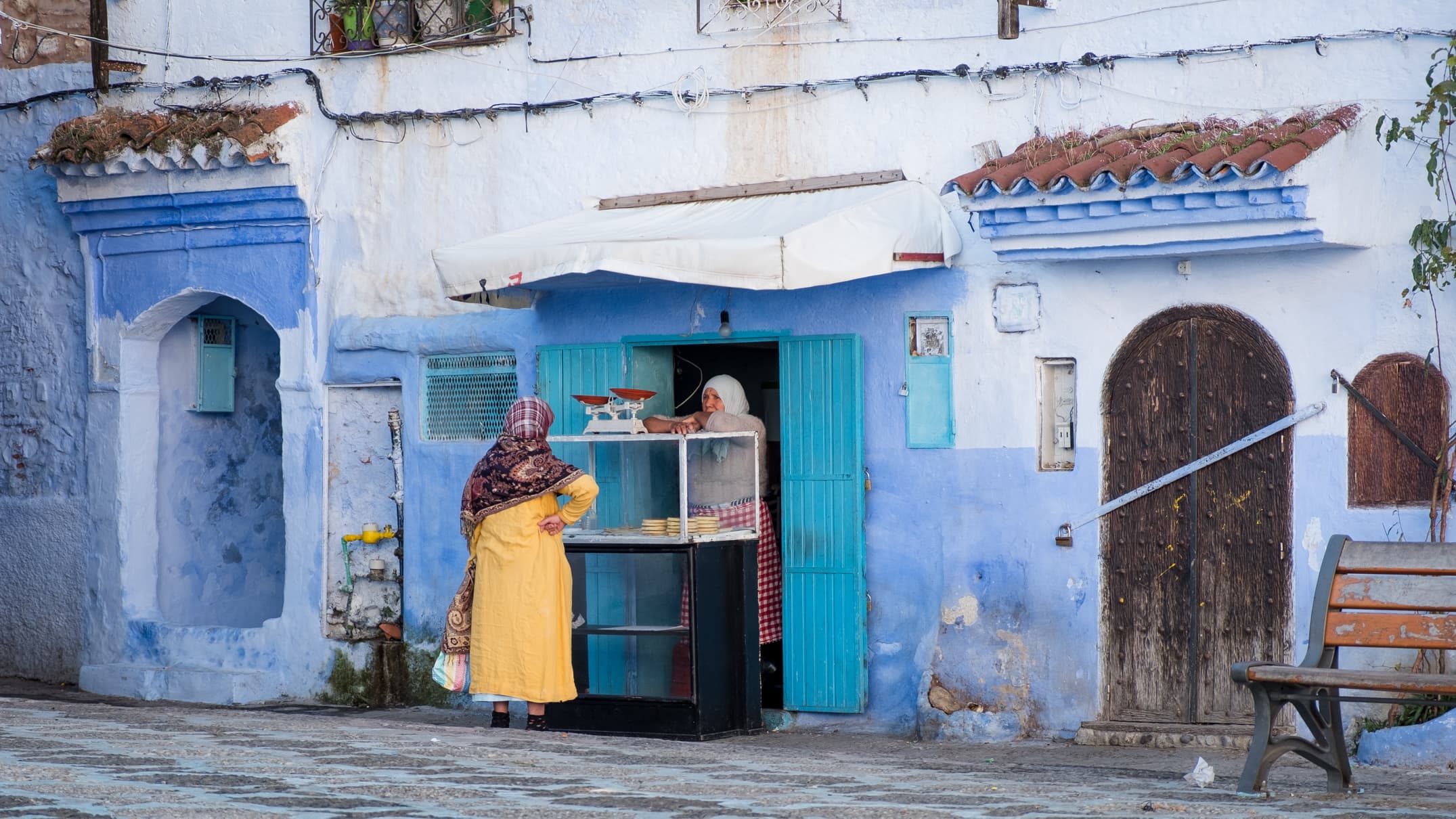 Two local women having a chat in-between running errands and selling baked goodies, Chefchaouen, Morocco