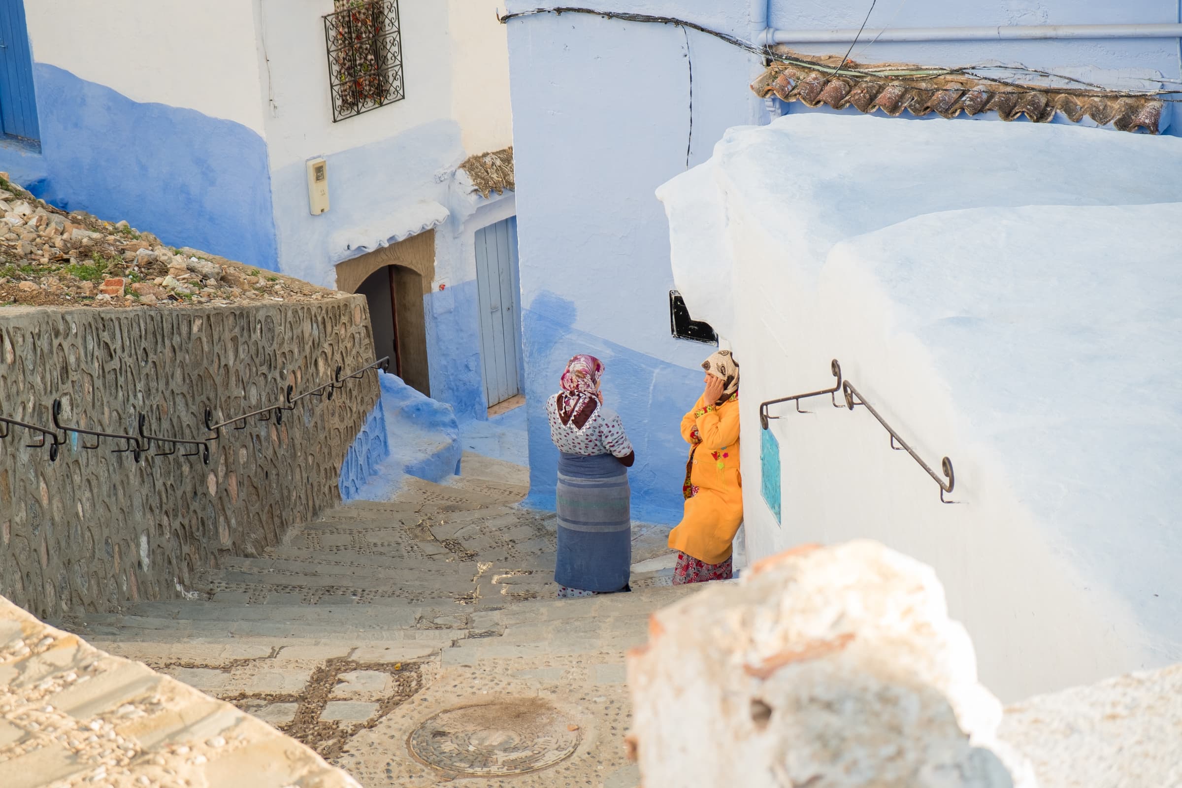 Women chatting in the side streets of Chefchaouen, Morocco