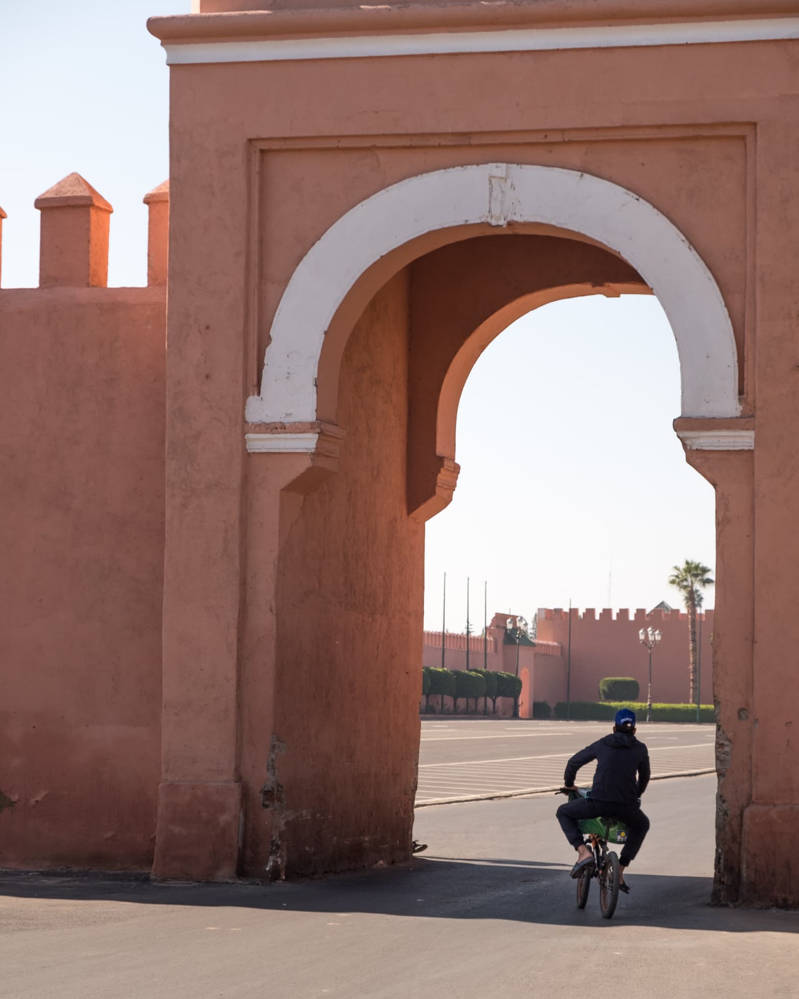 A man cycling through a city gate in Marrakesh