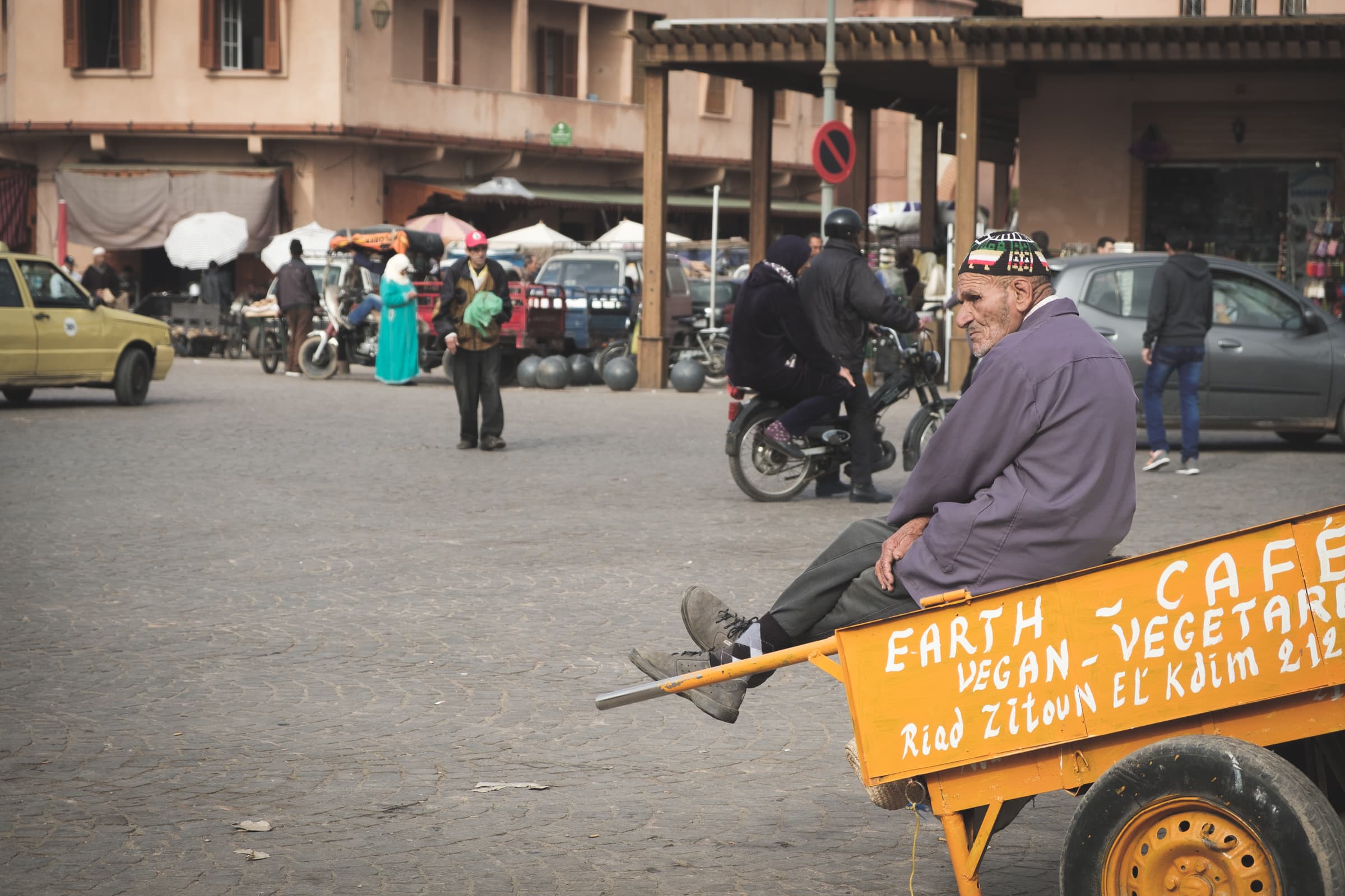 A man sat on a trailer advertising a vegetarian restaurant in Marrakesh