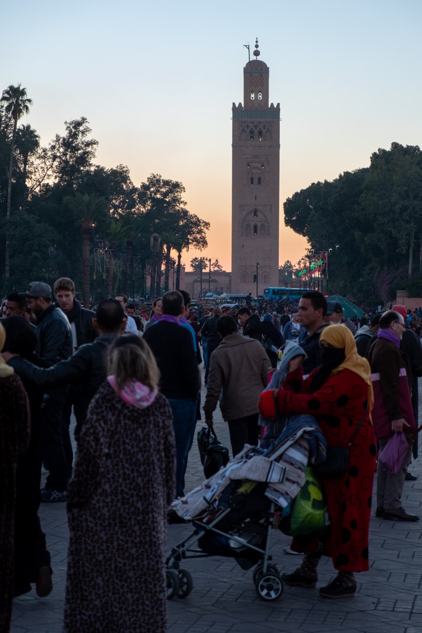 A busy avenue leading to a mosque at sunset in Marrakesh