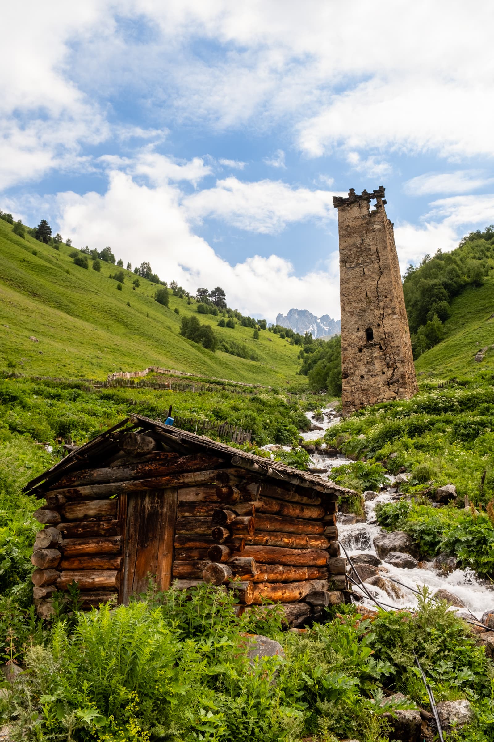 Early morning in Adishi, Idyllic view of a Svan tower with a wooden cabin and blue skies