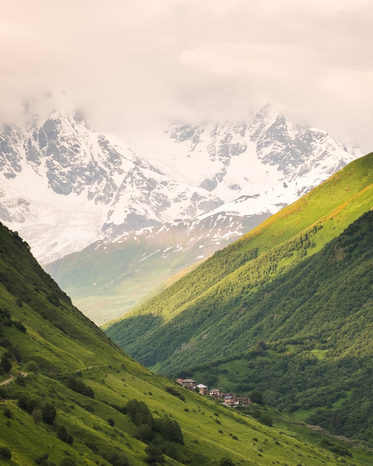 The almost abandoned village of Khalde with towering snow covered peaks, Svaneti, Georgia