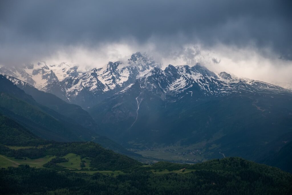 Black storm brewing brewing over the snowy Caucasus mountains from the Mestia Cross viewing platform