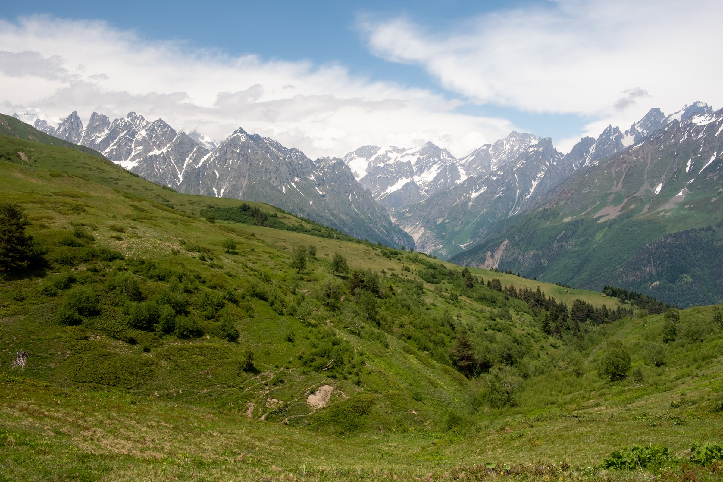 Blue skies, green slopes and snowy mountains in the distant, on the way to Koruldi lakes