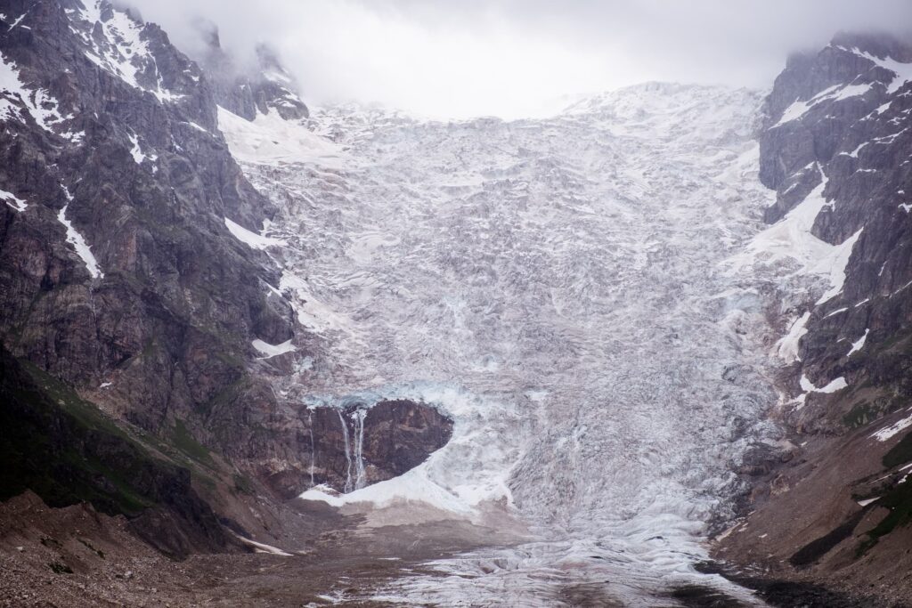 Closeup of Adishi glacier with broken away sections of glacier and waterfalls, Svaneti, Georgia