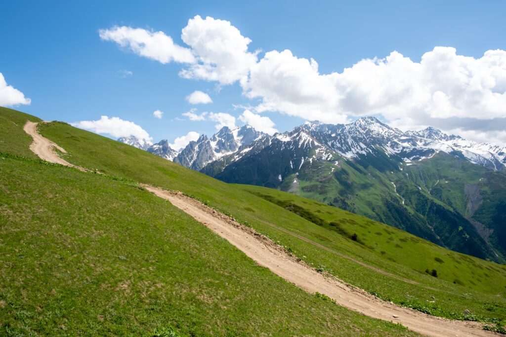 Idyllic alpine scene with green meadows and blue skies on the road to Koruldi lakes