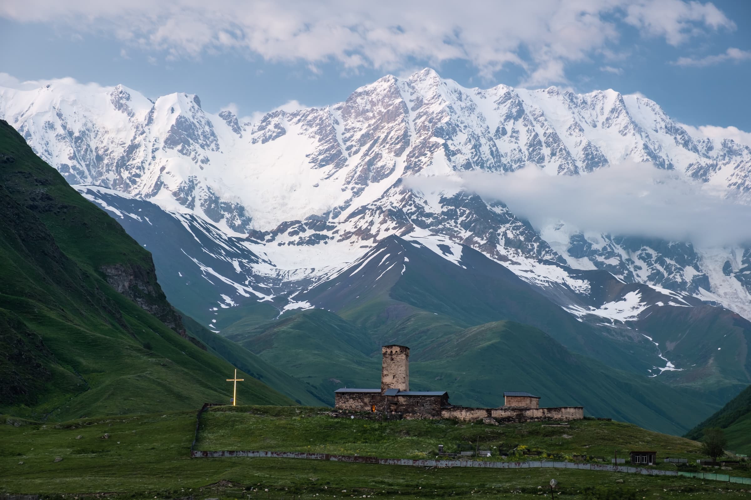 Lamaria church of Ushguli flanked by the snow covered Shkhara mountain