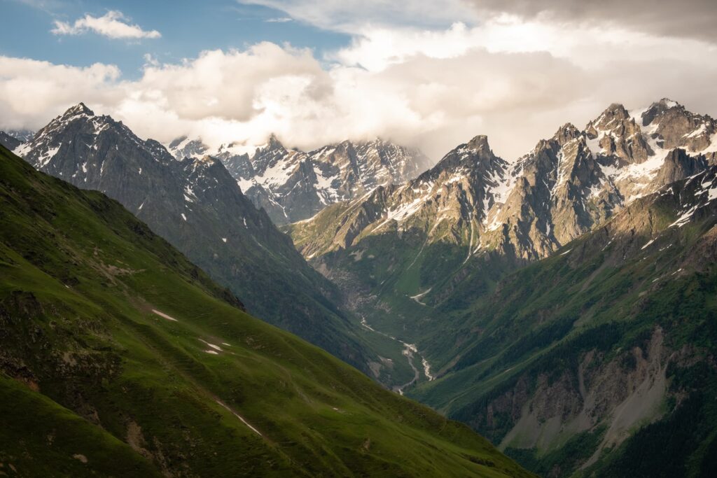 A storm in the menacing peaks with blue skies above from Koruldi lakes