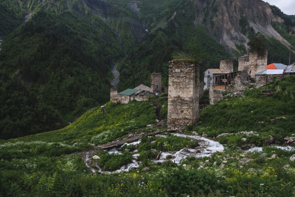Svan towers of Adishi with surrounding mountains, streams and waterfalls