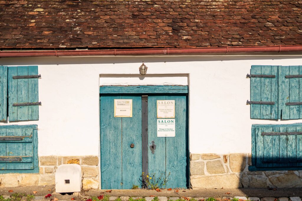 White wine cellar building with baby blue doors and shutters in Unterretzbach