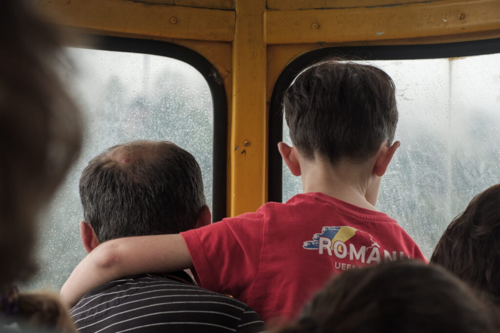 A man holding up his little boy looking out of the cable car window