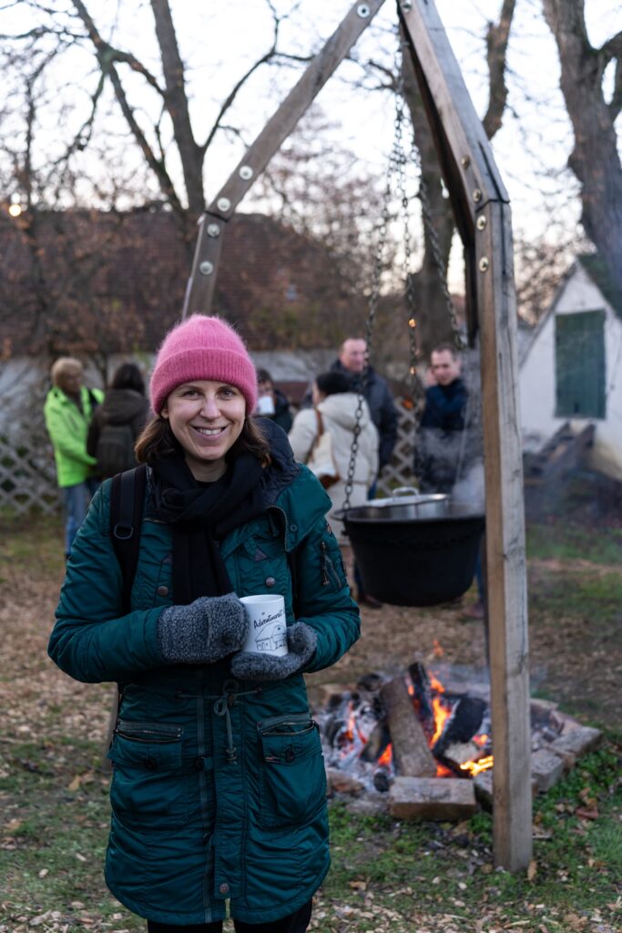 Caroline drinking weissegluhwein from a cauldron at Unterstinkenbrunn Adventmarkt