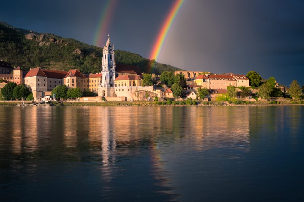 Dürnstein and its cathedral with a dazzling double rainbow across the Danube