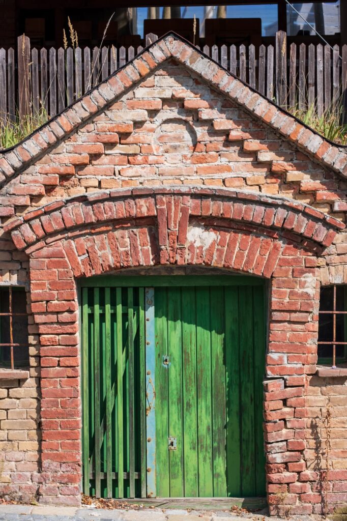 Small red brick wine cellar in Stammersdorf with green wooden door