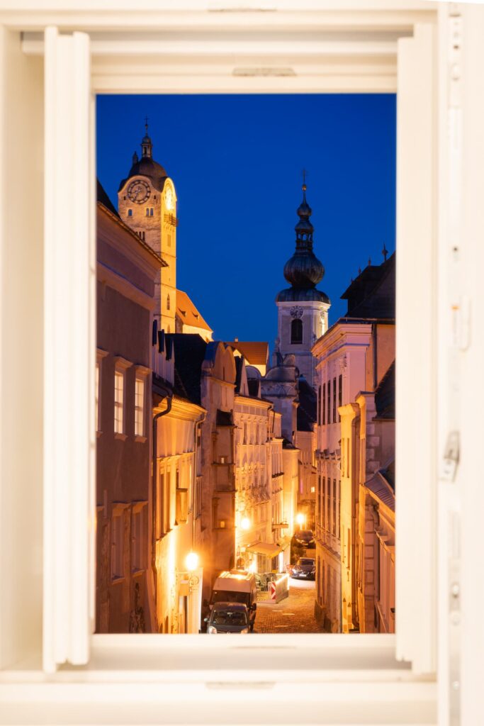 Stein with its narrow streets, medieval buildings and church towers in the evening through an apartment window