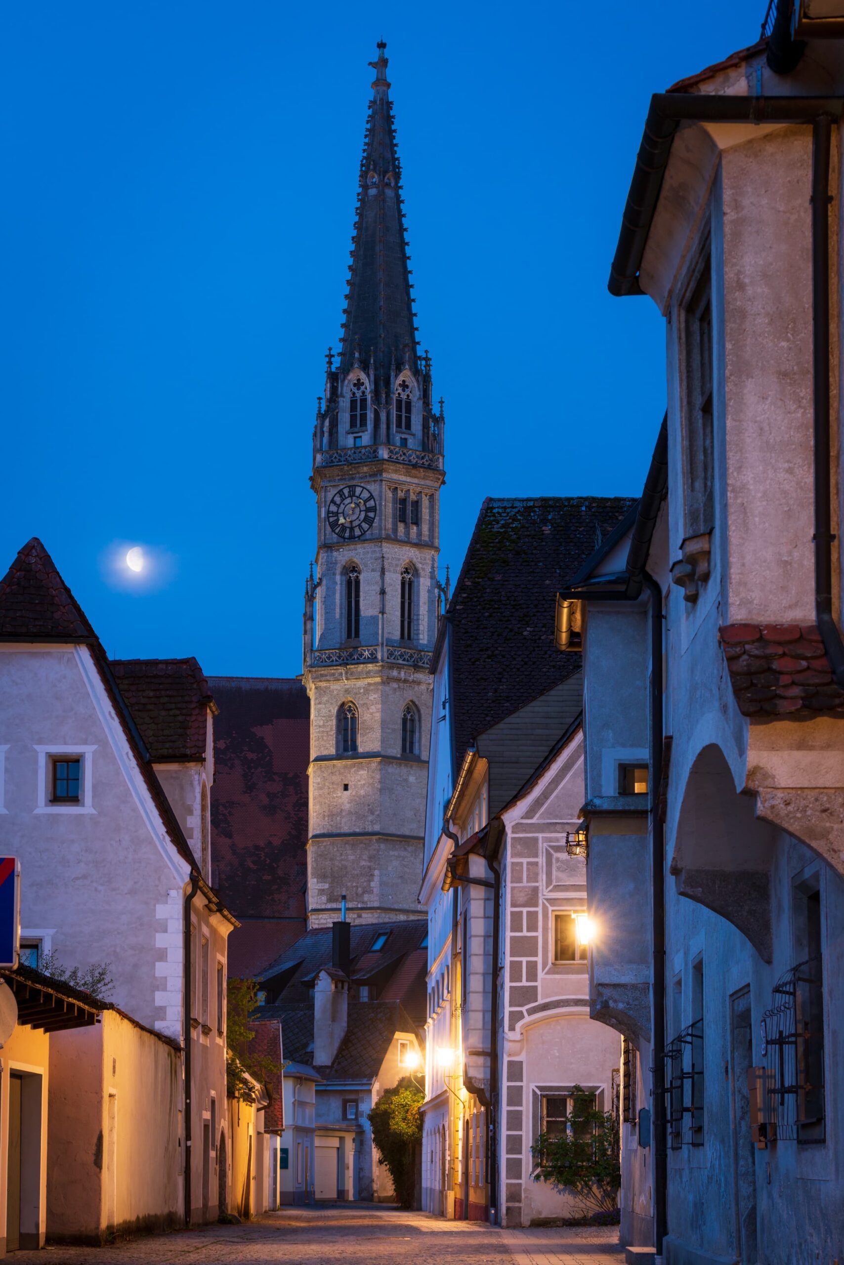 Early morning in Steyr with streetlights and fading moon illuminating the medieval cobbled stree