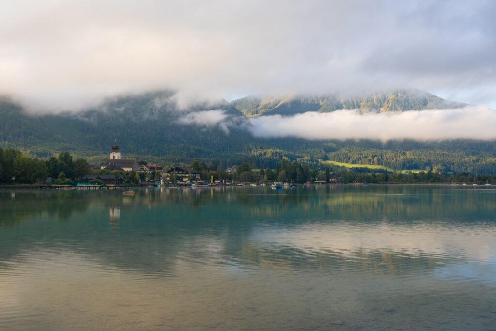 Early morning light over Strobl with low hanging clouds on Wolfgangsee