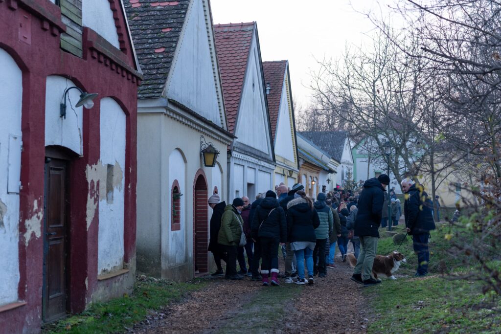 A colourful Kellergasse full of people during the Unterstinkenbrunn Adventmarkt