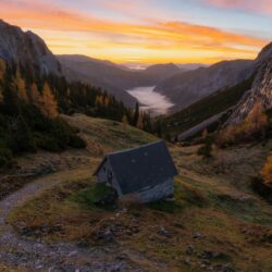 Burning sunrise over Bodental and a cute small brick building near Häuslalm Hochschwab